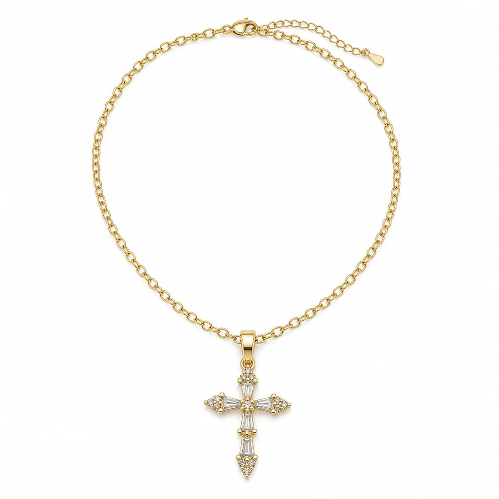 A gold chain necklace with a cross pendant adorned with clear baguette and round-cut stones, displayed on a clean white background.