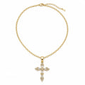 A gold chain necklace with a cross pendant adorned with clear baguette and round-cut stones, displayed on a clean white background.