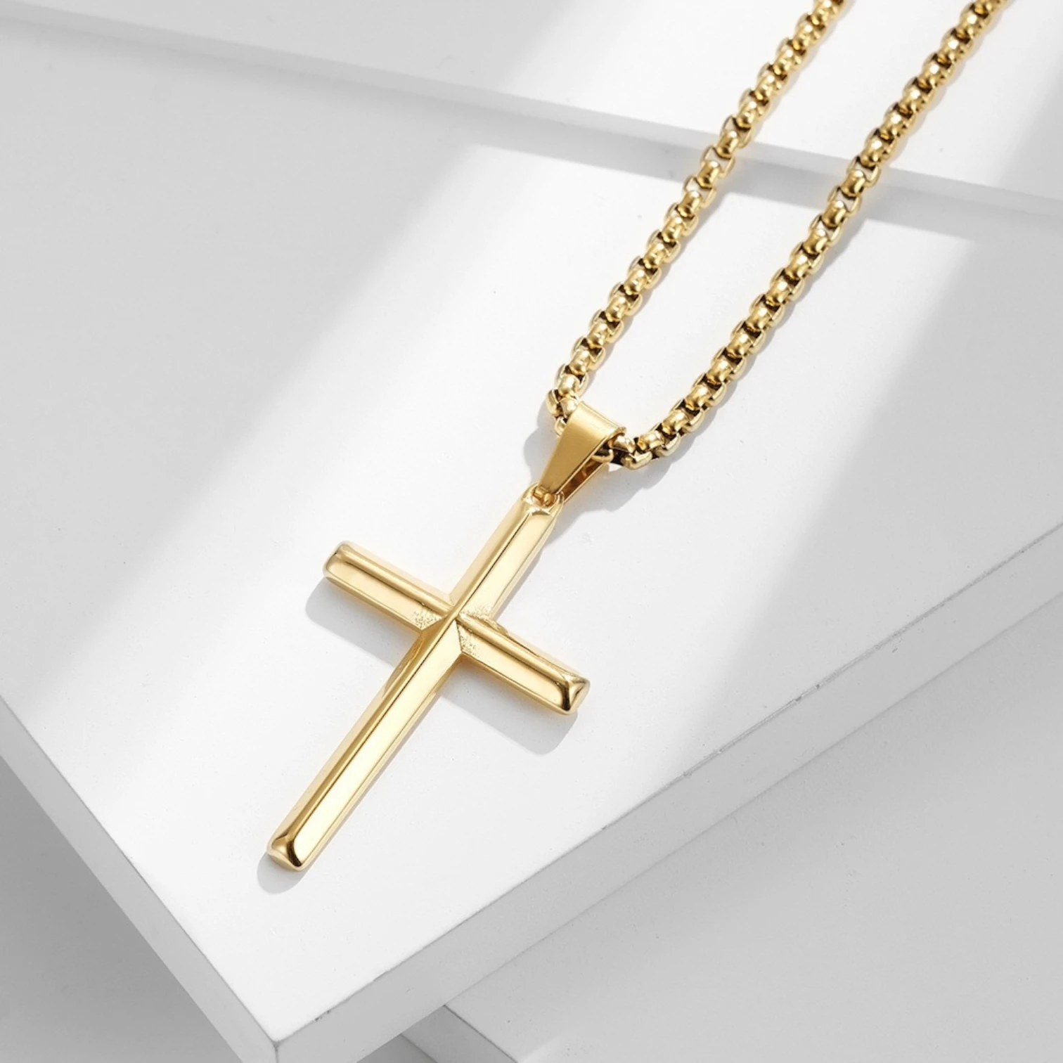 Gold cross necklace on a white background